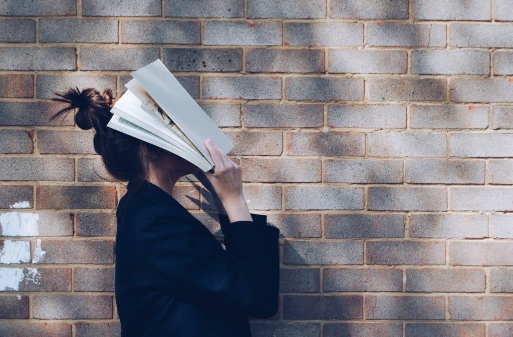 djevojka je pokrila glavu knjigom